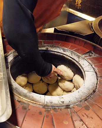 MRT「松山」駅側の赤いゲートから入ると、すぐ出てくるのが行列必至の「福州世祖胡椒餅」。窯にペタペタ胡椒餅を貼っている様子など、作っているところを間近で見られるのも楽しいです！