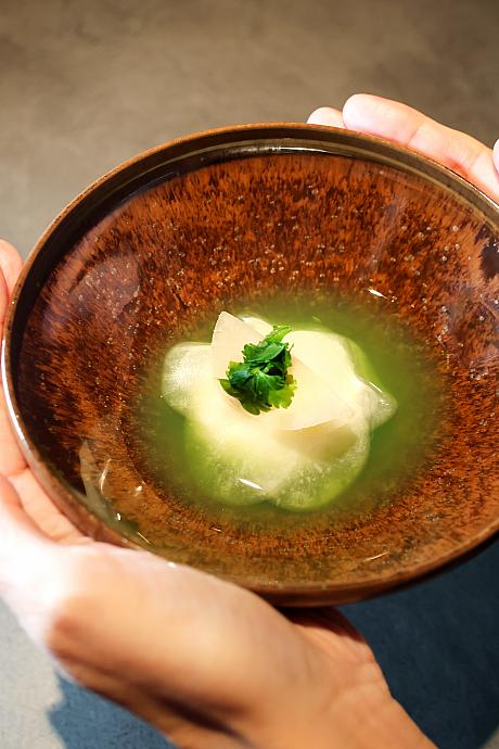 <b>[椀物]蛤の真薯 蕪 パセリ</b><br>冷たい料理から温かな料理へ。立ち上がる海鮮やパセリの香りがさらなる食欲を刺激します。出されたのは、ふんわりとした蛤の真薯とシャキシャキの蕪。やさしい味わいのお出汁がそれぞれを1つにまとめています。