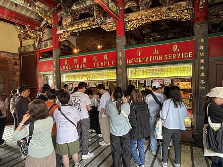 定番の恋愛の神様・月老の前や、お守り売り場はやはり大人気。お守りは、カウンター前に置かれた紙に欲しい商品の番号を書いて渡すスタイルです。番号札を受け取って、呼ばれたら受け取りに行きます。価格は40元〜300元ほどで、かわいいものからシンプルなデザインまで種類豊富です。