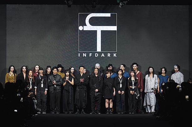 デザイナーの郭瑋氏(写真中央・長髪で髭の方)は、2011年にブランドを設立。現在もロンドン・ファッションウィークに参加しており、現地でのショー終了後すぐ台湾に戻って本イベントに参加しているとのことです。今季はポスト・アポカリプス(終末後)をテーマに、ブランドコンセプトである「解体と再構築」を表現。1着の服に複数の用途を持たせたデザインが特徴です。余談ですが、とても堪能な日本語でインタビューに答えてくれました！<br>画像提供：臺北時裝週 Taipei Fashion Week