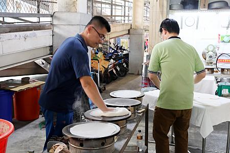 そんな「潮州春捲大王」が長年地元で愛され続けているのは、手作りの「餅(ビン)」＝皮にあるのかも？店の裏手にある市場の片隅で、せっせと作られていました。生地を鉄板に押し付けるように伸ばして焼きます。