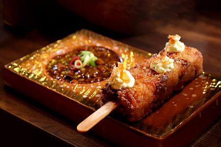 「<b>炸米糕冰棍(120元)</b>」も人気です。台湾の宴会でよく出てくる「紅蟳米糕」を、一人でも食べられるようにアイスキャンディー風にアレンジ。ホタテとスルメイカをおこわに混ぜ込み、桜エビを散らして色と香りを添えています。これに合わせるのは辛くない麻婆ソース。一口食べると、次の一口を急かしてくる味です。