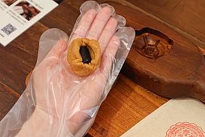 ピーナッツ糖でゴマ餡を包み込み、専用の型へそっとセット。最後に型を「トンッ！」と打ち付けると、縁起物の「平安亀」が完成します！