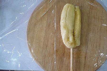 ４． バナナの皮をのぞいてビニールの上におき、割り箸（棒）をさす。
