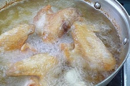 ５． 中温の油で鶏手羽をきつね色になるよう揚げる。