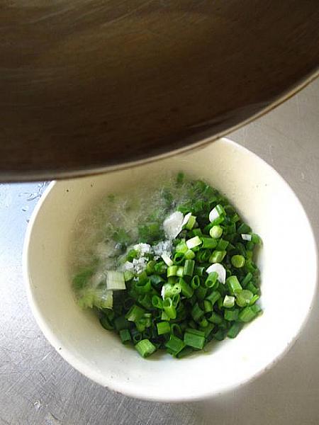 7．小口切りにした葱に塩ひとつまみを入れて熱した油大さじ2を注ぐ。（葱油）