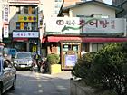 右前方にお店が見えます。徒歩約５分。また地下鉄９号線シンノンヒョン（新論峴・Sinnonhyeon・925）駅４番または５番出口から徒歩約２分。