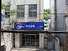 右側に釜山銀行が見えてきます。お店は、釜山銀行のすぐ前の建物の２階。（駅から徒歩約7分）