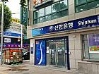 「Shinhan Bank」の角を右折し、約60m直進します。