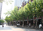 右手に見える赤茶色の建物の１階にサービスアパートの入り口があります。